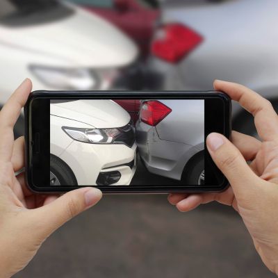 Taking photos of a car accident to provide to your auto accident lawyer.