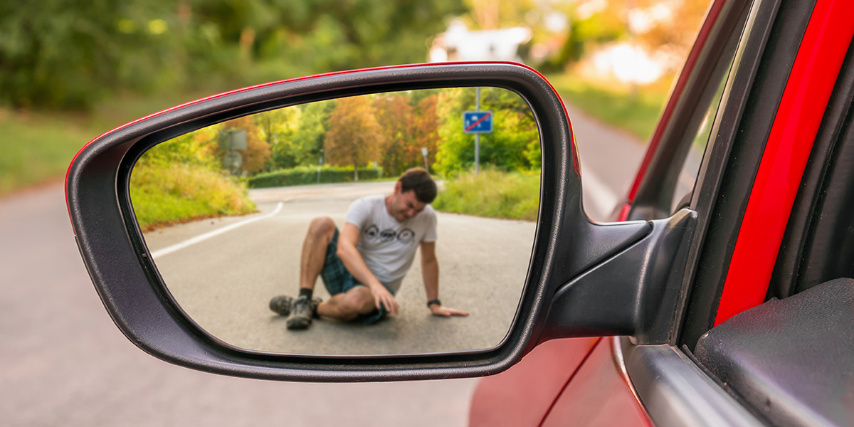 Person driving looking in the side mirror at a pedestrian they just hit with their vehicle